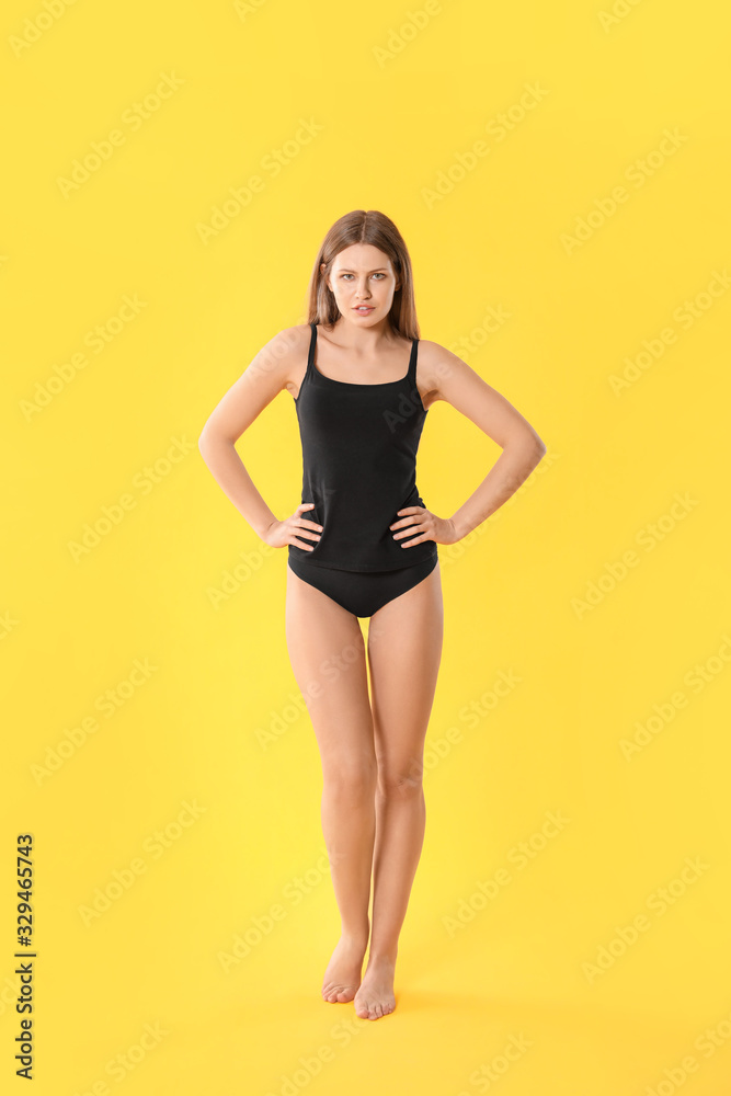 Beautiful young woman in underwear on color background