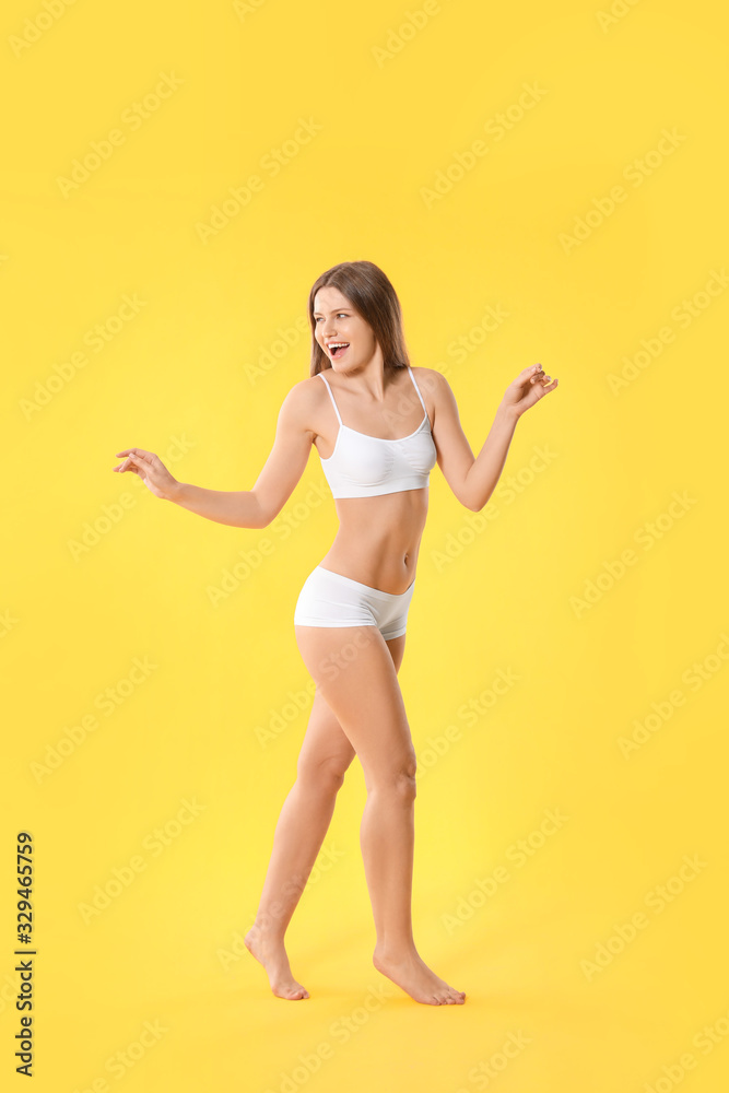 Beautiful young woman in underwear on color background