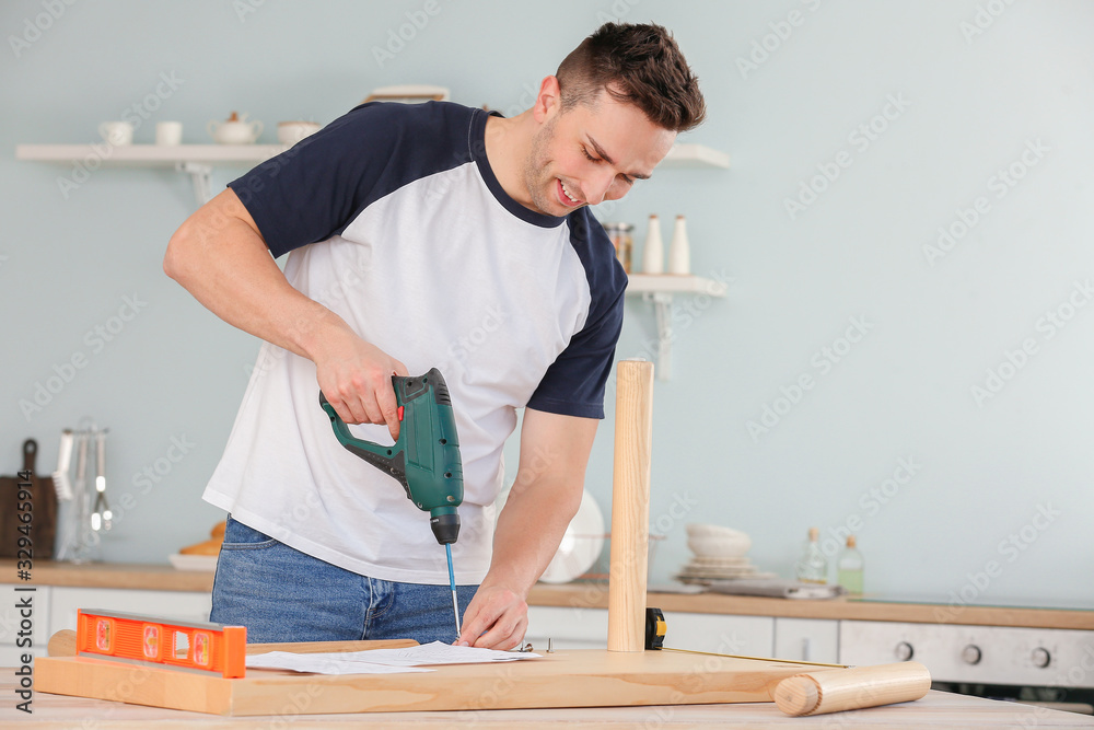 Young man assembling furniture at home Young man assembling furniture at home