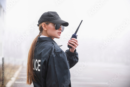 Photo Female police officer patrolling city street