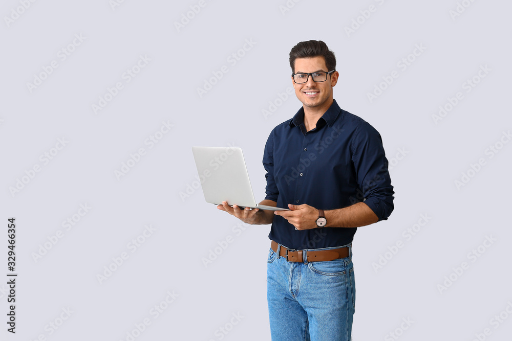Handsome man with laptop on light background Handsome man with laptop on light background