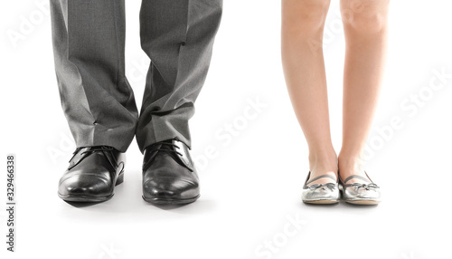 Legs of father and his little daughter on white background