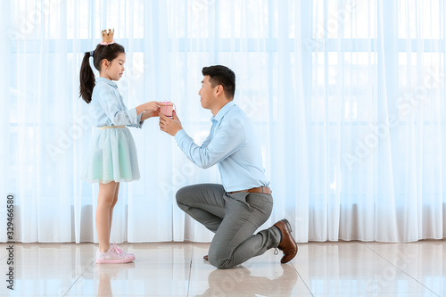 Asian man greeting his little daughter at home