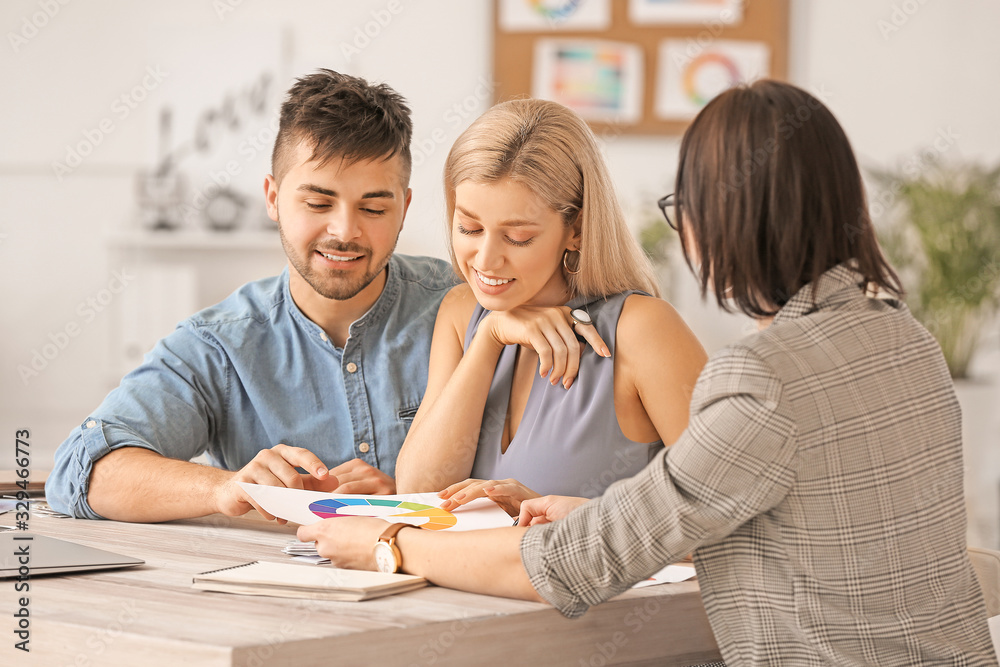 Female interior designer working with couple in office Female interior designer working with couple in office