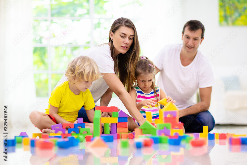 Naklejka premium Kids play with toy blocks. Family at home.