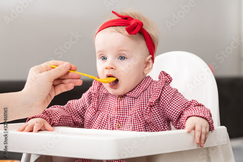 Mother Feeding Baby With Spoon