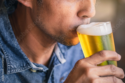 Happy friends drinking and toasting beer at brewery bar restaurant. Friendship concept with young people having fun together at cool vintage restaurant.