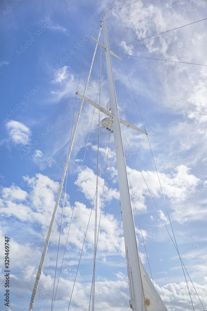 Obraz premium sailing ship mast on a sunny day at a dock in Florida with white clouds in the background