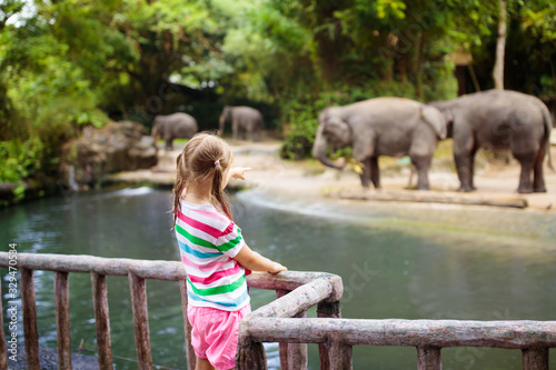 Fototapeta Naklejka Na Ścianę i Meble -  Kids feed elephant in zoo. Family at animal park.