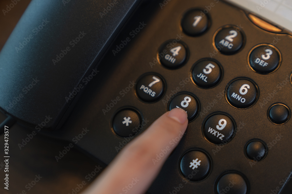 Hand press the phone button on the office desk. Hand press the phone button on the office desk.