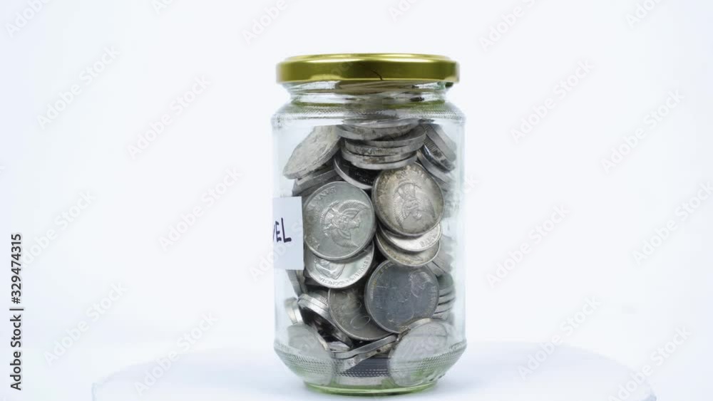 Glass jar filled by Rupiah coins for travel Glass jar filled by Rupiah coins for travel