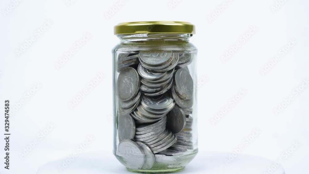 Glass jar with Rupiah coins and college word
