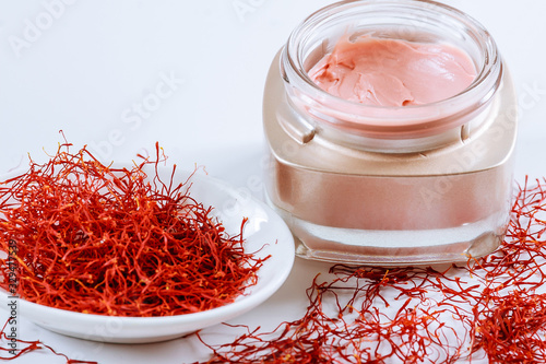 Saffron and cosmetic cream on a white background. Cream with saffron extracts.