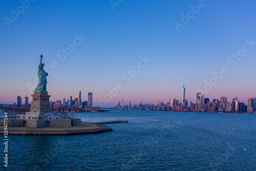 Statue of Liberty and New York Manhattan cityscape in background at sunset  USA