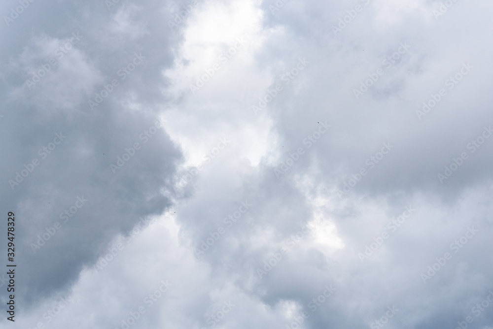 Dramatic gray and white clouds illuminated by back light from sun