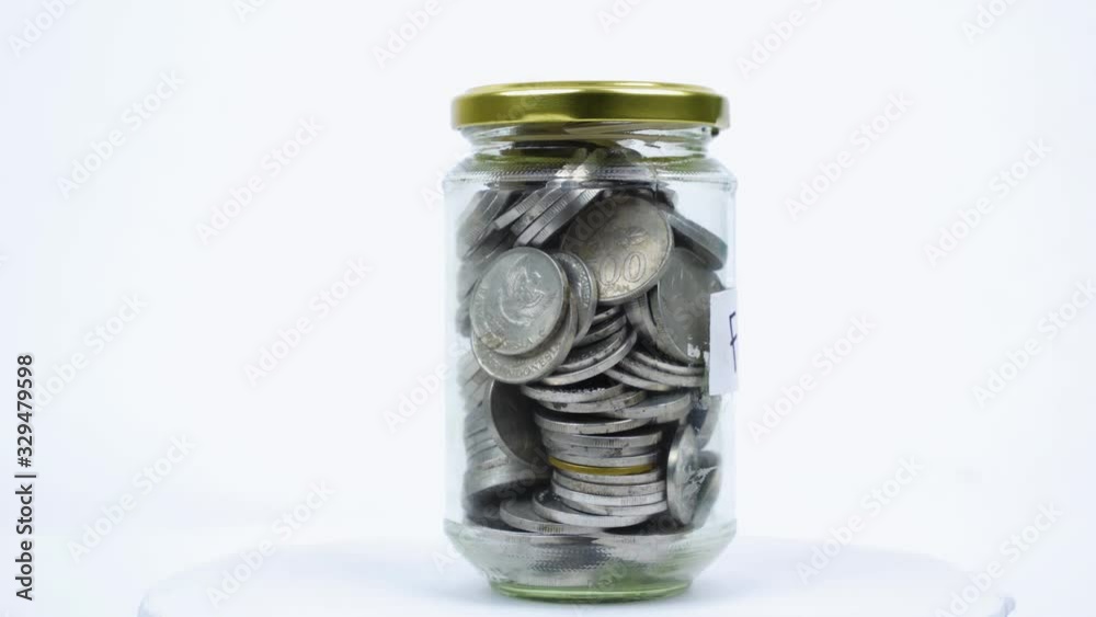 Rupiah coins in glass jar with family word Rupiah coins in glass jar with family word
