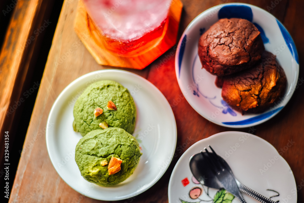 White chocolate matcha and Chocolate brownie brownies cookies in plate and iced red soda on wood table. White chocolate matcha and Chocolate brownie brownies cookies in plate and iced red soda on wood table.