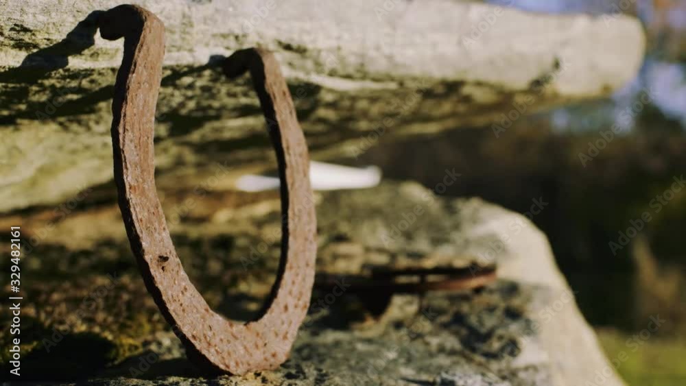 Rusted horseshoe on rock formation sunlit close-up IV Rusted horseshoe on rock formation sunlit close-up IV