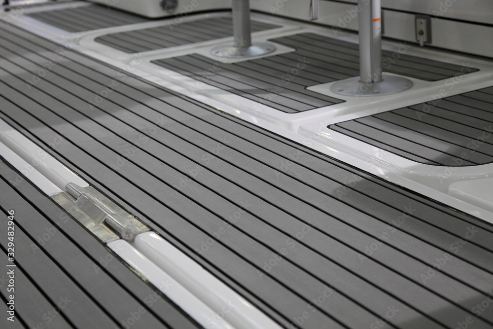 Luxury motor boat cockpit gray interior with marine teak floor deck design close up