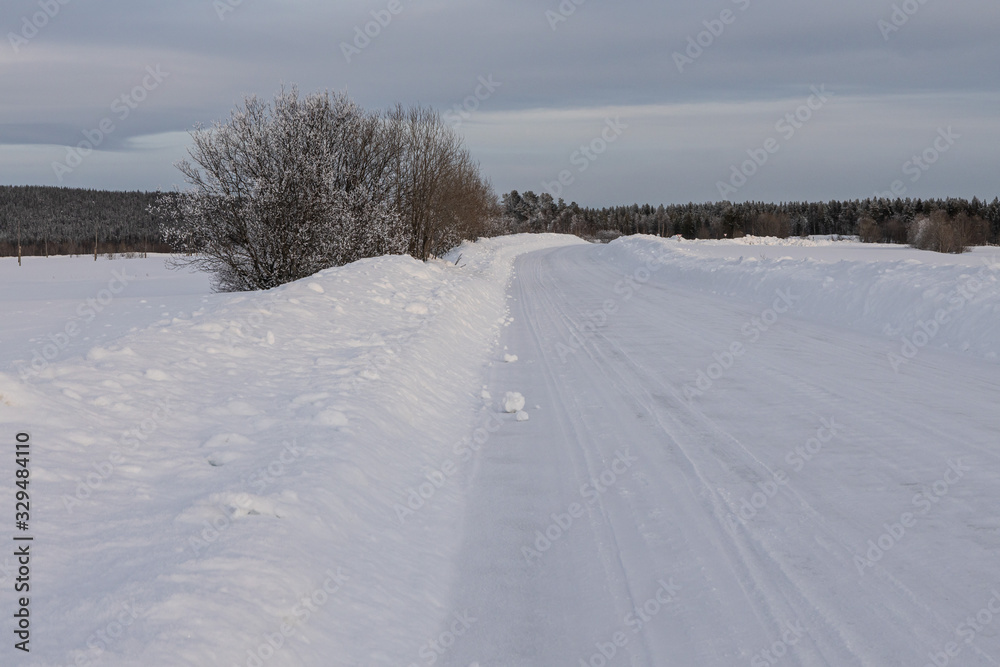 Winter landscape - snow-covered road and the clouds in the sky Winter landscape - snow-covered road and the clouds in the sky