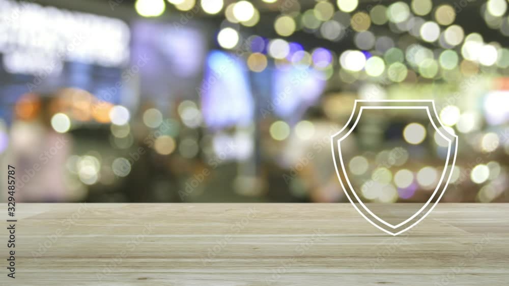 Airplane with shield flat icon on wooden table over blur light and shadow of shopping mall, Business travel insurance and safety concept