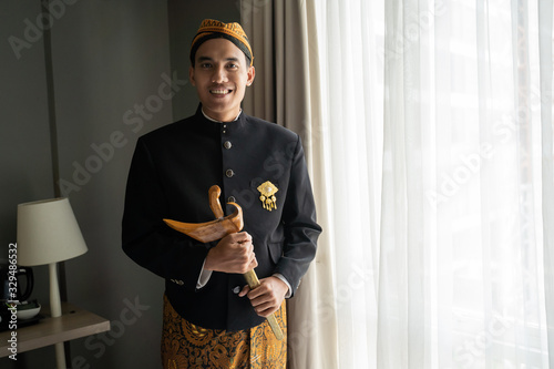 Asian man wearing traditional clothes,beskap and keris is traditional heritage clothes from Java,Indonesia photo
