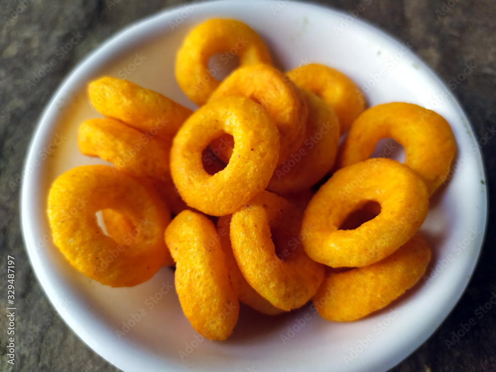 SOME YELLOW EATABLE FOOD PUT IN A BOWL ON STONE BACKGROUND