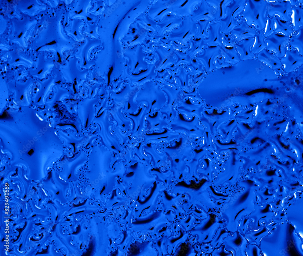 Blue drops of water on glass as an abstract background Blue drops of water on glass as an abstract background