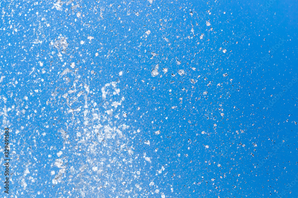 Splashing water from a fountain on a background of blue sky Splashing water from a fountain on a background of blue sky