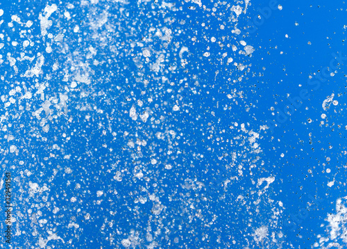 Splashing water from a fountain on a background of blue sky