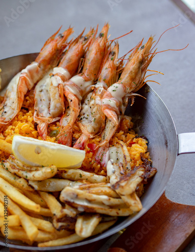 A set of fried rice with jumbo shrimp and fried potatoes, served in large portions.