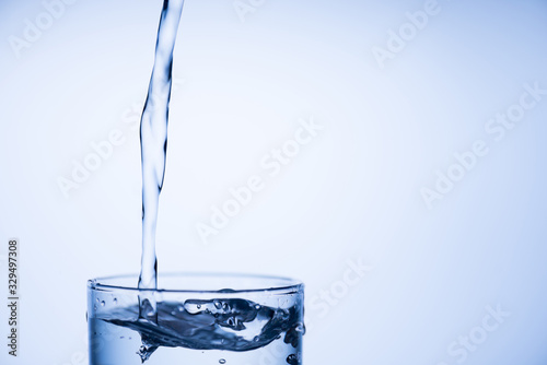 Cropped close up photo of top of glass of fresh pure clean water isolated over light pastel blue background with place for text empty blank space