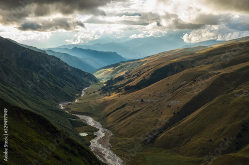 Scenic landscape with mountain river and small lake and blue mountains view from a top photo