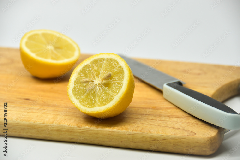 Two pieces of lemon on a wood cutting board. Two pieces of lemon on a wood cutting board.