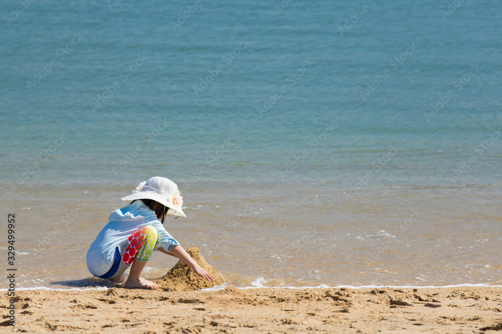 Obraz premium 海の砂浜で遊んでいる可愛い子供