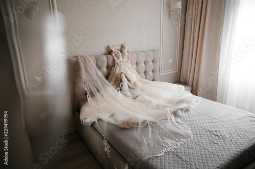  wedding white dress lying on the bed on a white background with a decorative doll
