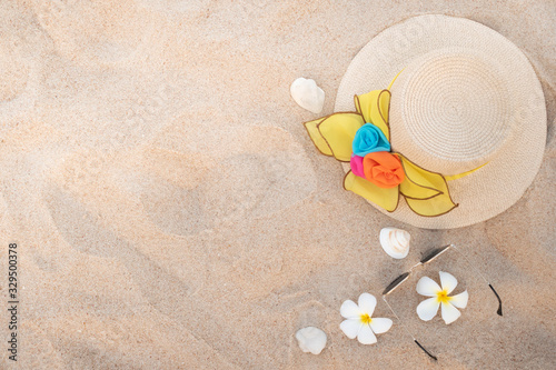 Top view of beach accessories with girl hat and shell on beach.