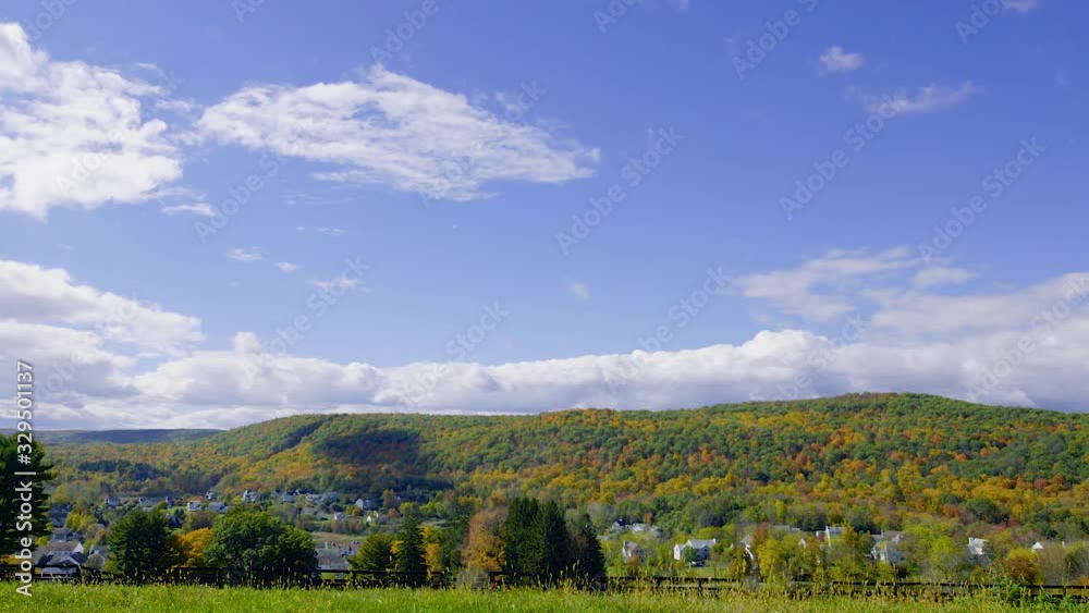 Scenic small town and mountains in autumn from horse farm grass in foreground wide Scenic small town and mountains in autumn from horse farm grass in foreground wide