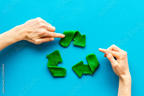 Recycling symbol - composition with hands - on blue background top-down