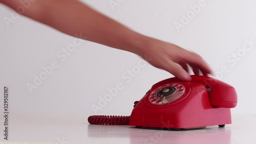 Old red telephone being dialed and speaker being seen. photo