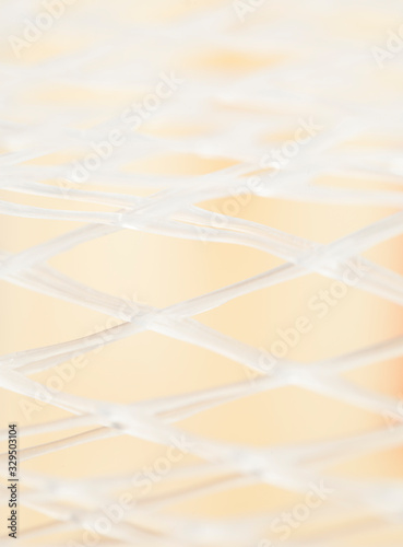 close up of white plastic net on beige  background cover