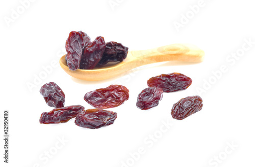 Dried raisins in a wooden spoon on the white background