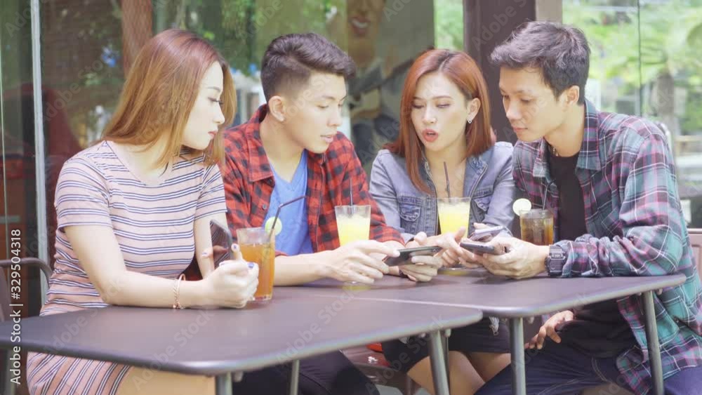 Group of young people using mobile phone in cafe Group of young people using mobile phone in cafe