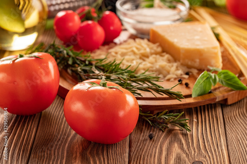 Ingredients for spaghetti bolognese with cherry tomatoes and basil on a wooden table