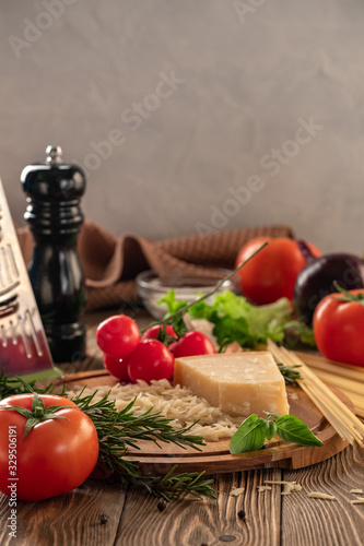 Ingredients for spaghetti bolognese with cherry tomatoes and basil on a wooden table