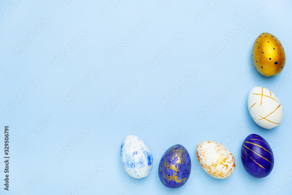 Happy Easter. Frame for text made of easter eggs trendy colored classic blue, white and golden on blue. Minimal style, top view, flatlay, copy space