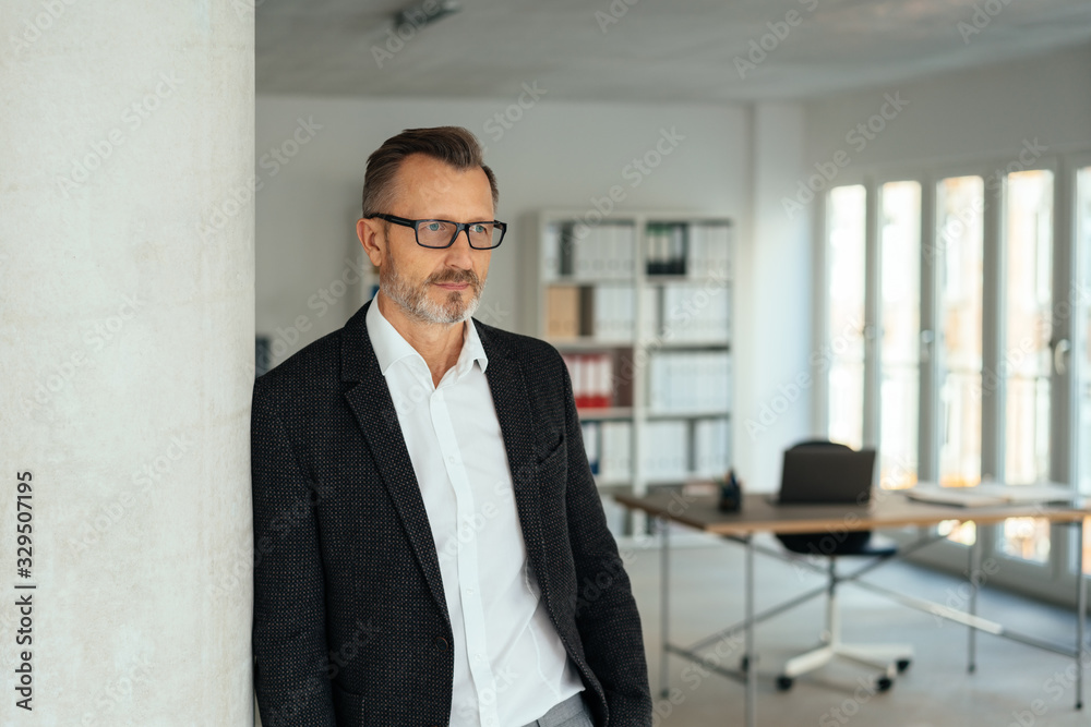 Businessman standing leaning against a wall Businessman standing leaning against a wall