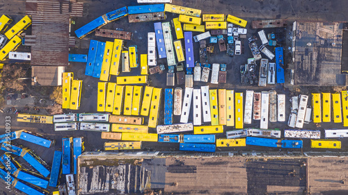 Transport creative art. Yellow and blue buses and cars aerial top view. abandoned transport parking. shabby and broken vehicle of the times of the USSR. Aerial top view drone photo. Kyiv Kiev Ukraine