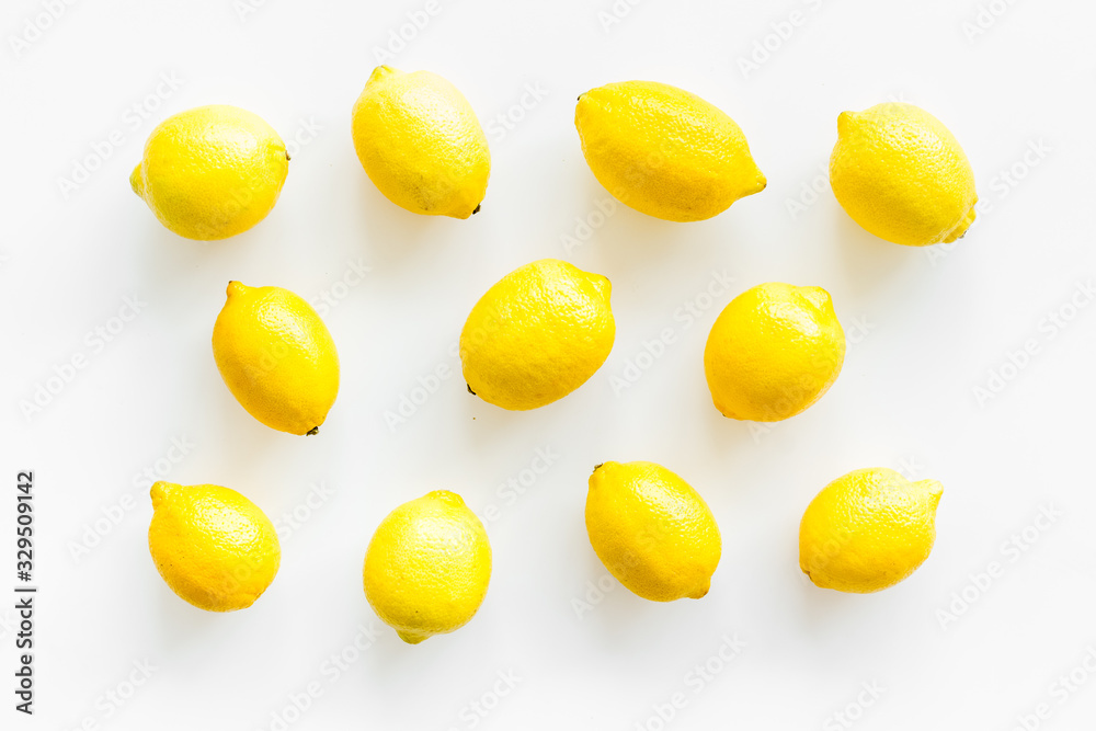 Lemons background - whole fruits - on white table top-down