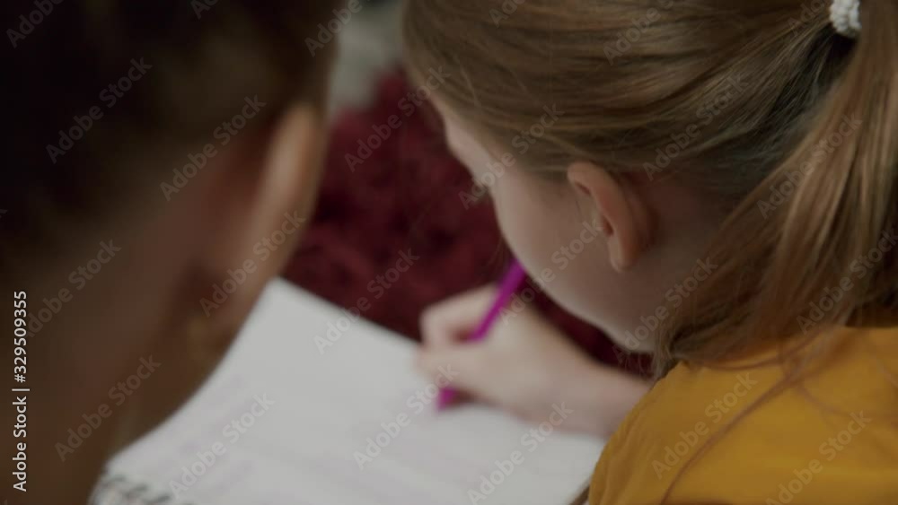 Close up Tutor Helping Little Girl With Her School Homework Close up Tutor Helping Little Girl With Her School Homework